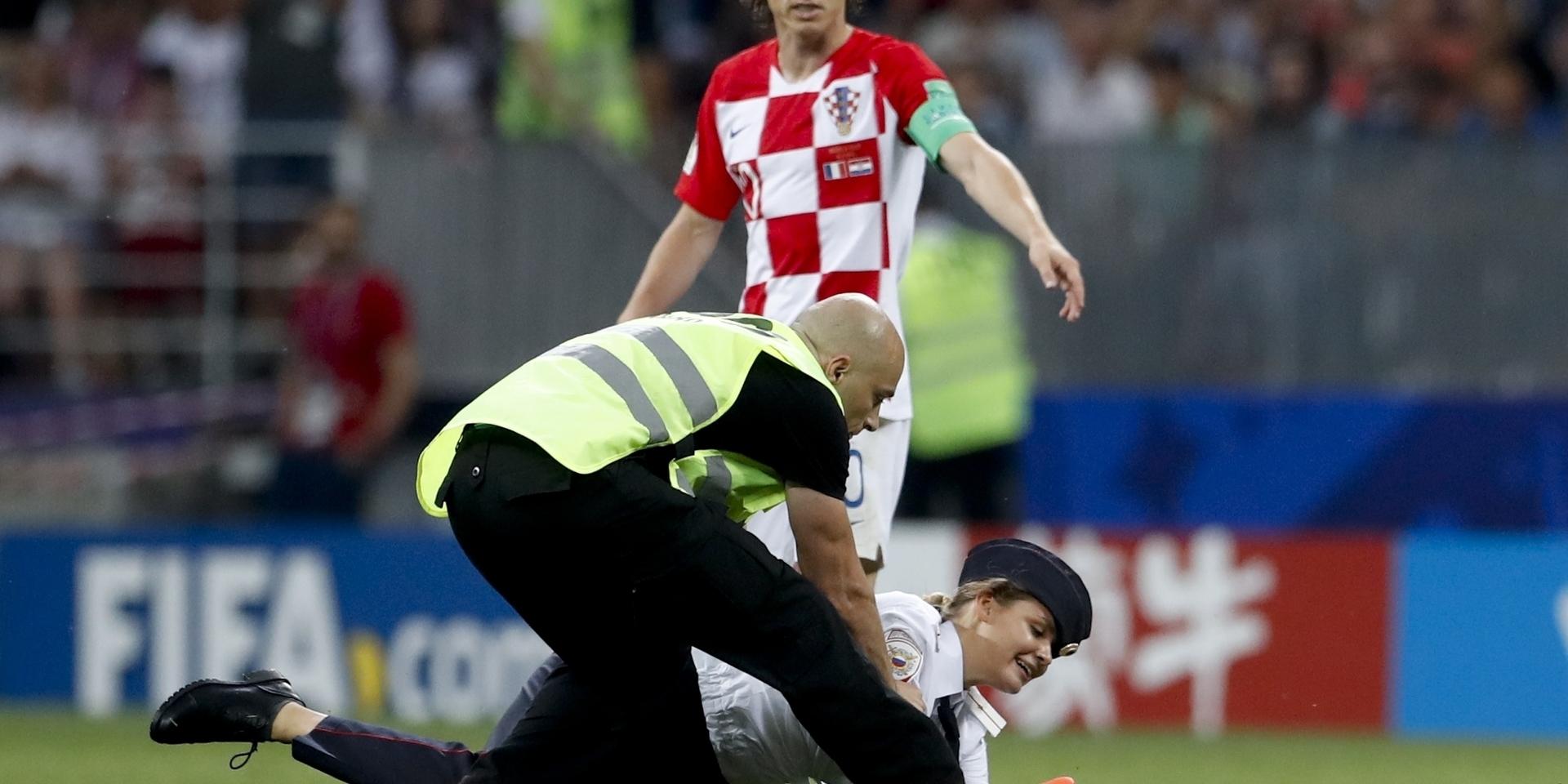 Sprang in på plan. En kvinna från konstnärskollektivet Pussy Riot brottas ned av vakter när hon sprang in på fotbollsplanen under finalen mellan Frankrike och Kroatien i söndags. 
