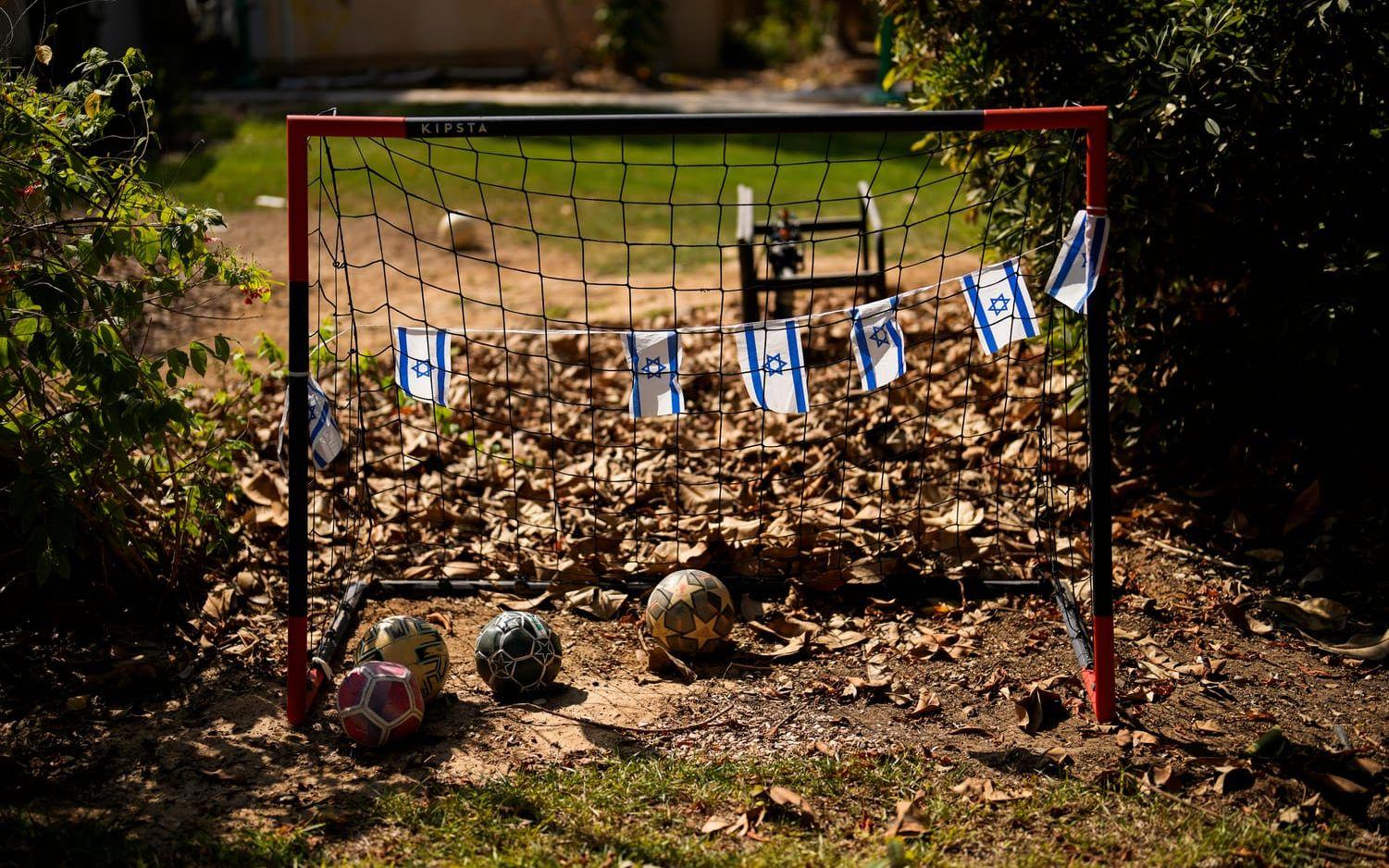 Israeliska flaggor vid ett fotbollsmål i en kibbutz som attackerades av Hamas den 7 oktober. Arkivbild.