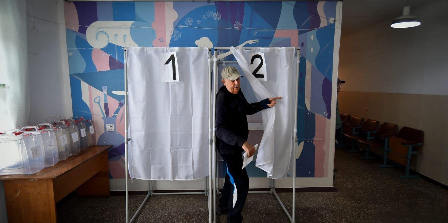 En man lämnar röstningsbåset i Melitopol, där en kritiserad folkomröstning hållits för att införliva regionen med Ryssland.