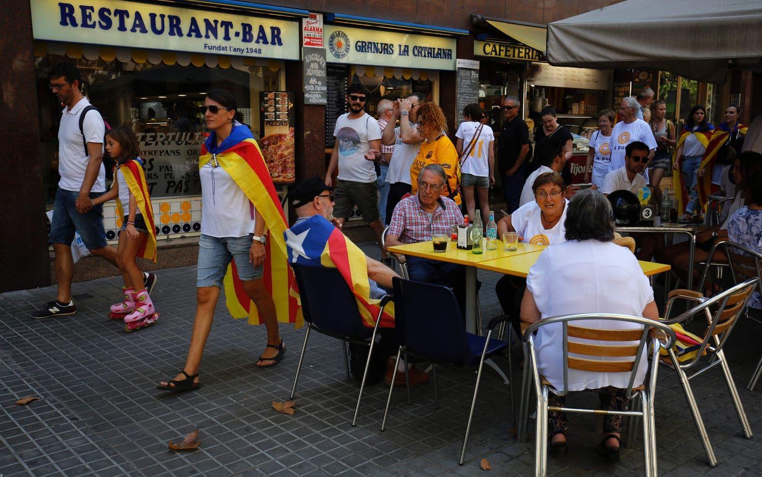 På gator och restauranger draperade folk sig i den katalanska flaggan. Bild: TT