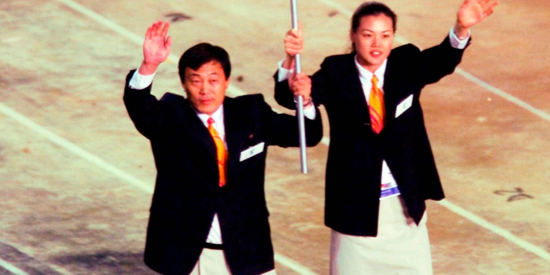 Nordkoreas judocoach Pak Jung-Chul, till vänster, och Sydkoreas basketbollspelare Chung Eun-Sun vinkar till publiken under öppningsceremonin för OS i Sydney 2000, då de tillsammans bar en flagga som representerade ett enat Korea. Arkivbild.