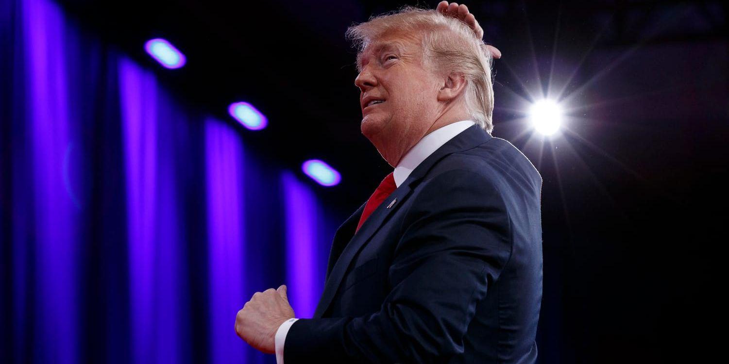 USA:s president Donald Trump skämtar om sitt hår vid ett partievenemang i februari i år.