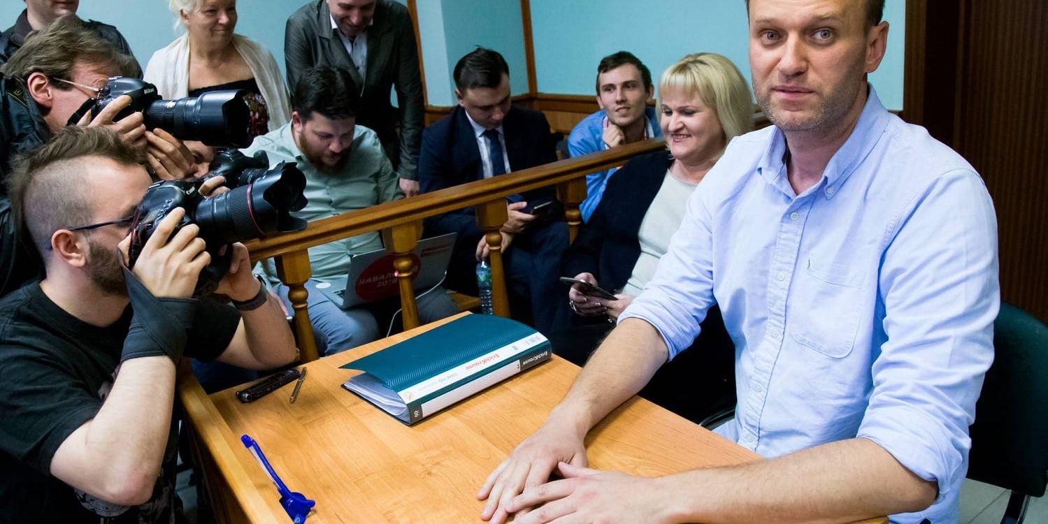 Den ryske oppositionsledaren Aleksej Navalnyj (till höger) pratar med medier under en paus vid förhandlingarna den 16 juni, då han dömdes för att ha planerat protester som saknade myndigheternas tillstånd. Arkivbild.