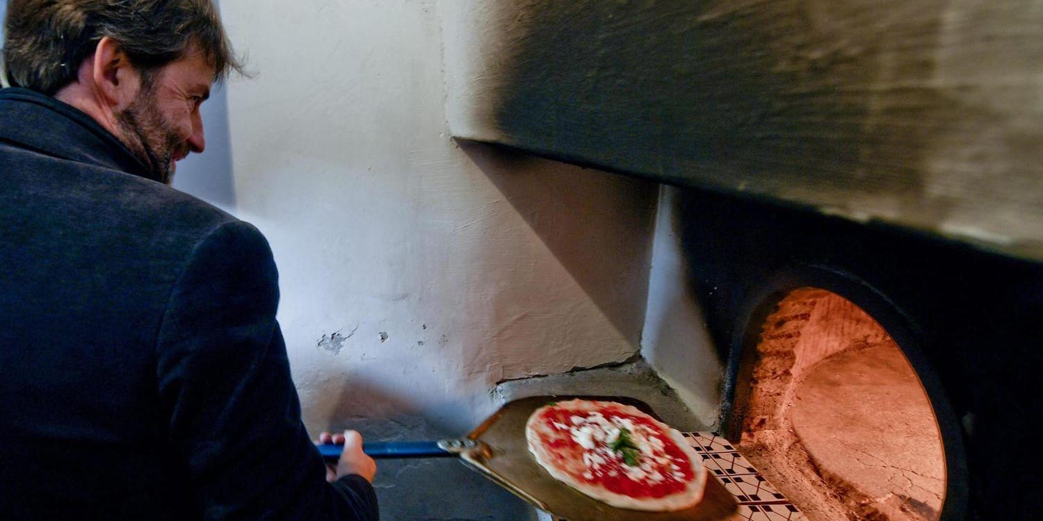 Italiens kulturminister Dario Franceschini firar att "pizzaiuolo" kommit med på Unescos världsarvslista med att grädda en klassisk pizza i den stenugn där den allra första margheritan bakades 1889.