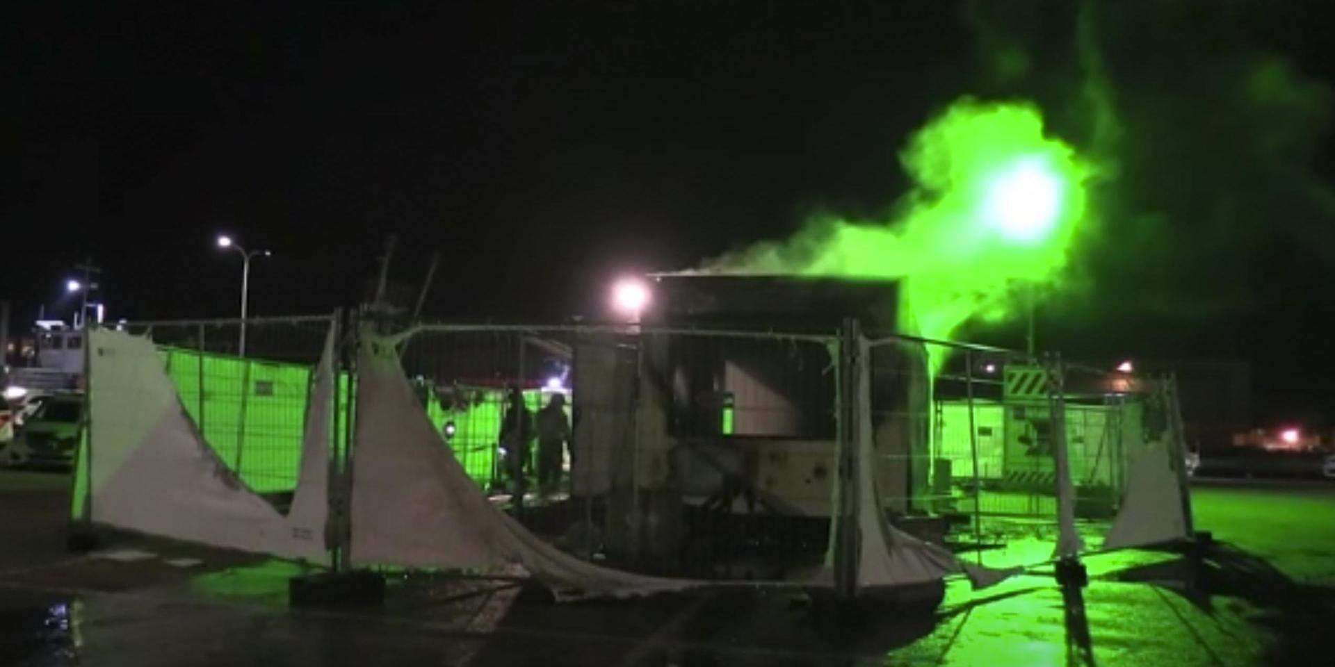 En utbränd covidtestanläggning på en parkeringsplats i Urk utanför Amsterdam efter helgens protester.