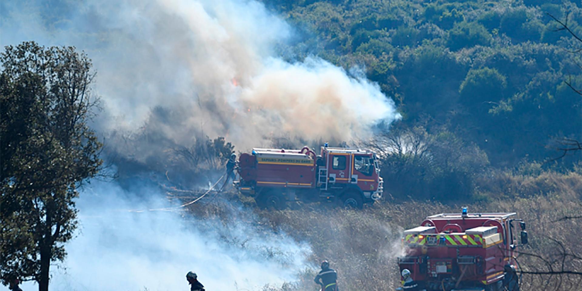 Brandmän i arbete på en äng utanför Bordezac i södra Frankrike. Hundratals brandmän försökte tillsammans med vattenbombande flygplan bekämpa skogs- och terrängbränder i södra Frankrike på tisdagen.