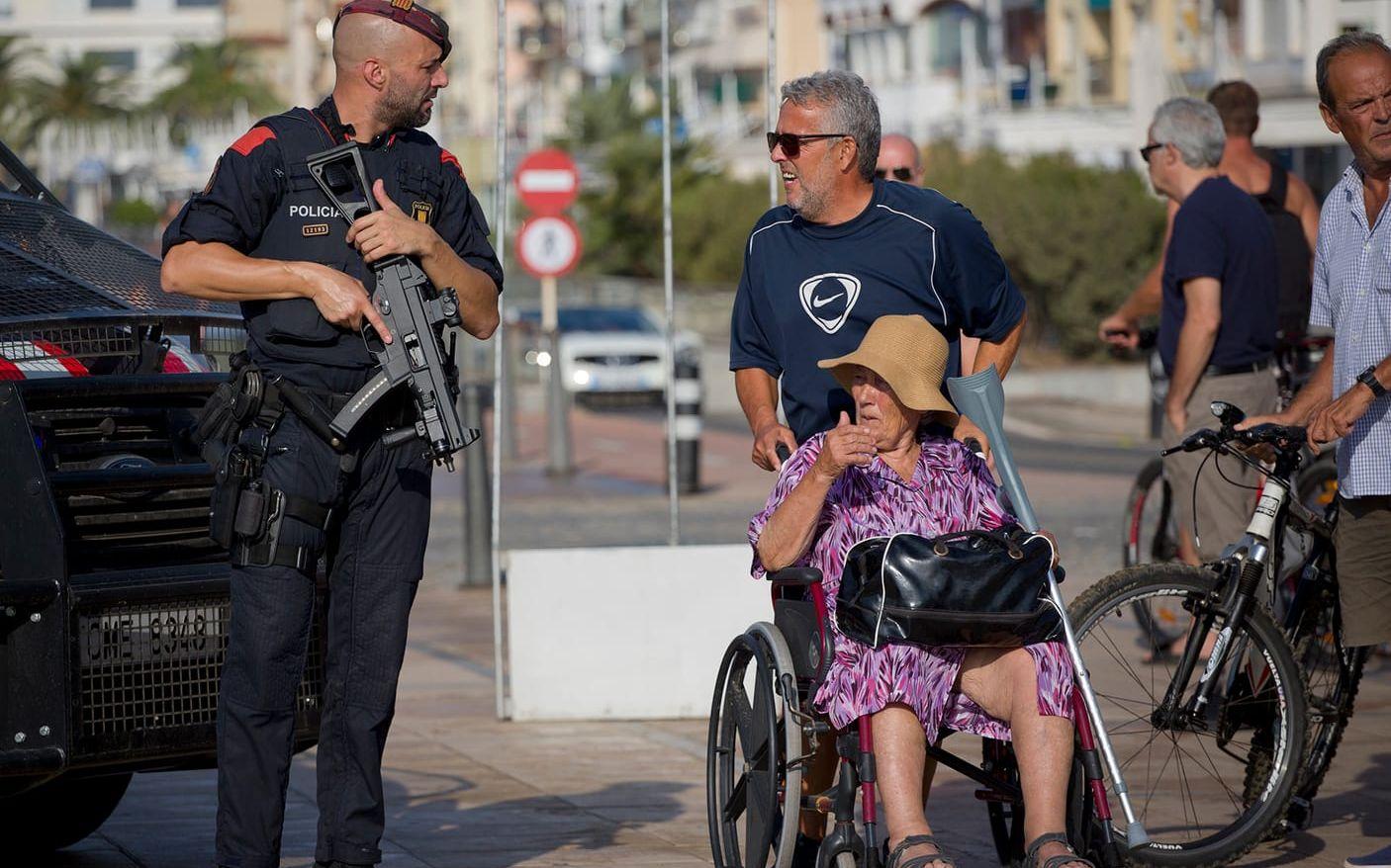 Polis i samtal med några civila förbipasserande på strandpromenaden i Cambril, där fem terrorister gick till attack och dödades.FOTO: Emilio Morenatti/AP
