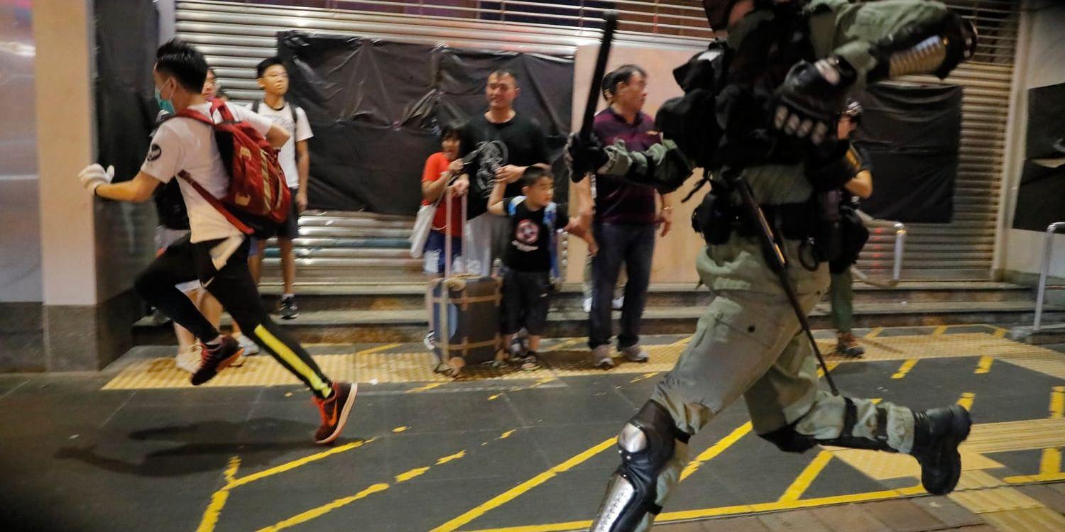 Polis jagar en demonstrant i Hongkong under söndagen. 