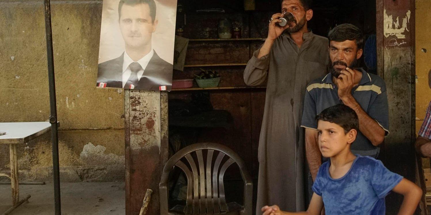 Bashar al-Assad blickar ner från ett porträtt på en gata i staden Dayr al-Zawr.