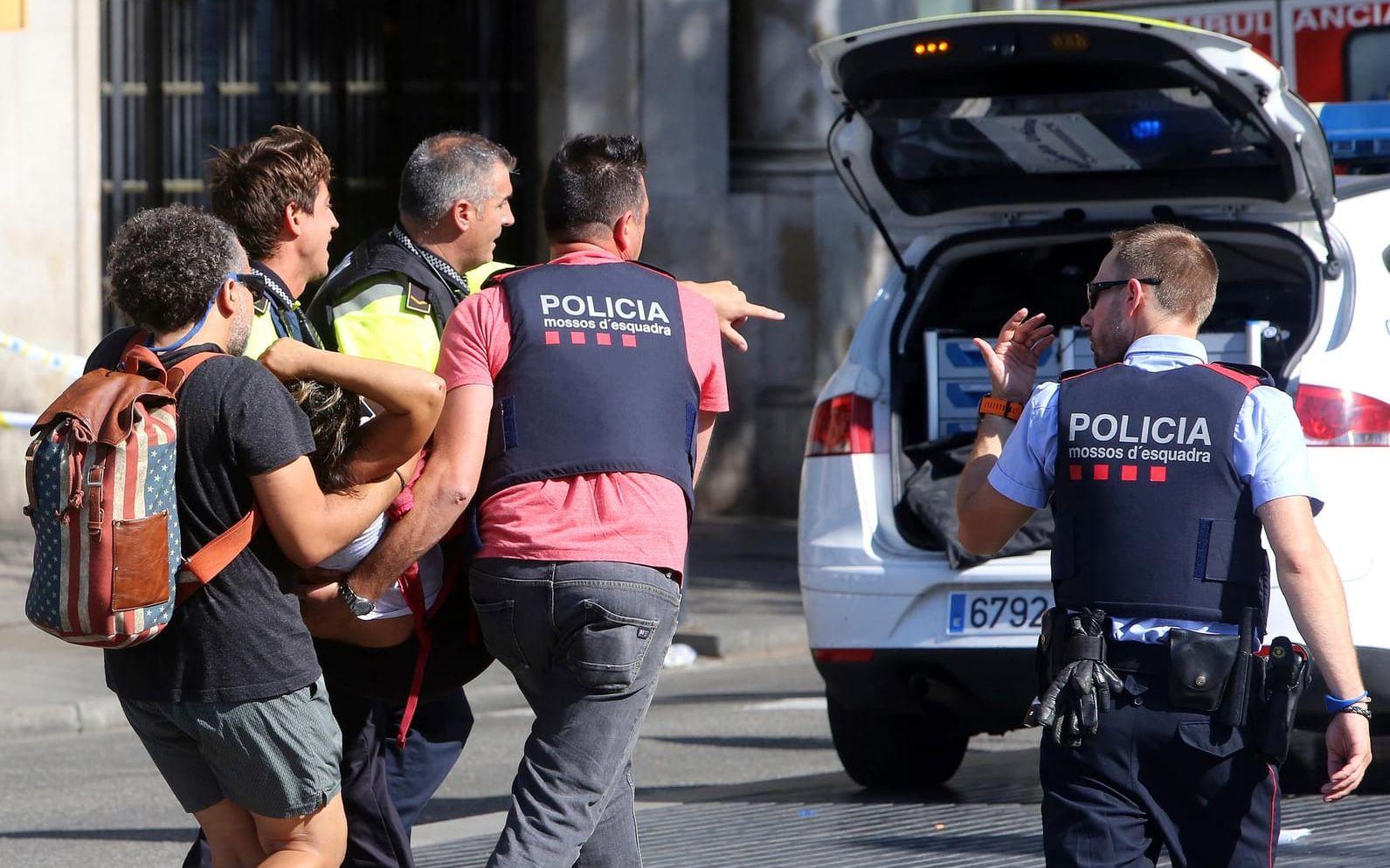 Polis och ambulanspersonal undsätter skadade efter skåpbilsattacken i Barcelona. Bild: TT
