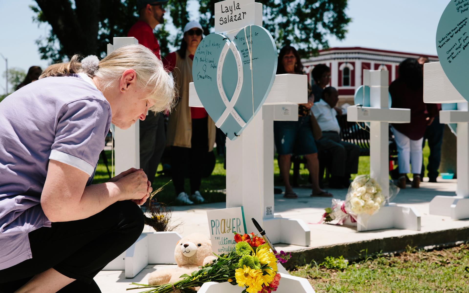 En kvinna ber på en minnesstund för de barn som dödats i skolskjutningen.