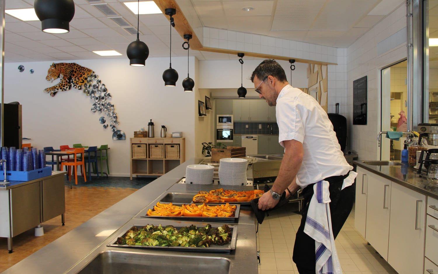 Mats Andersson ställer fram plåtarna med grönsaker. Snart kommer eleverna in i matsalen för lunch.