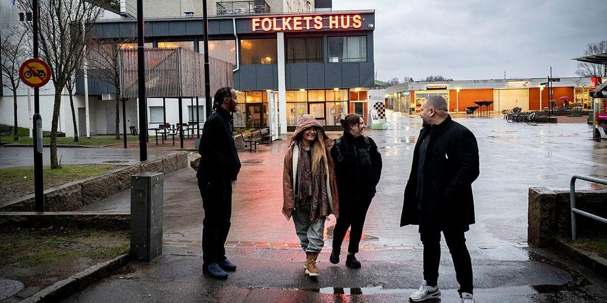 Fyra personer står utanför Folkets Hus.