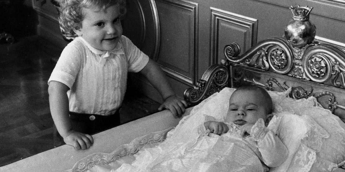 Prins Carl Philip, 3 år, kollar in lillasyster Madeleine i dopklänning. Samma dopklänning som burits av alla kungabarnen och barnbarnen kommer även bäras av den nyaste medlemmen i kungafamiljen, prinsessan Adrienne som döps i juni. Arkivbil.