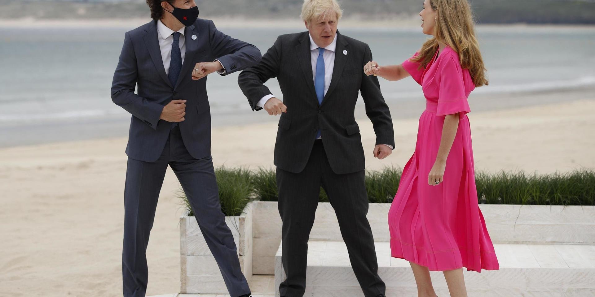 Kanadas premiärminister Justin Trudeau, Storbritanniens dito Boris Johnson samt hans fri Carrie Johnson hälsar coronasäkert på varanda med armbågarna.