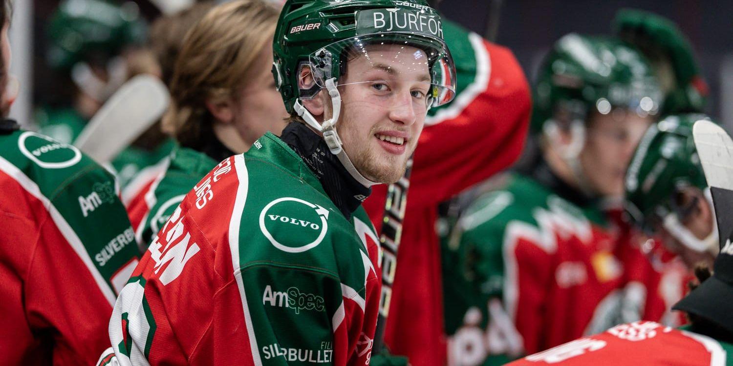 Liam Elfosson sitter i avbytarbåset i Frölundamundering och ler.