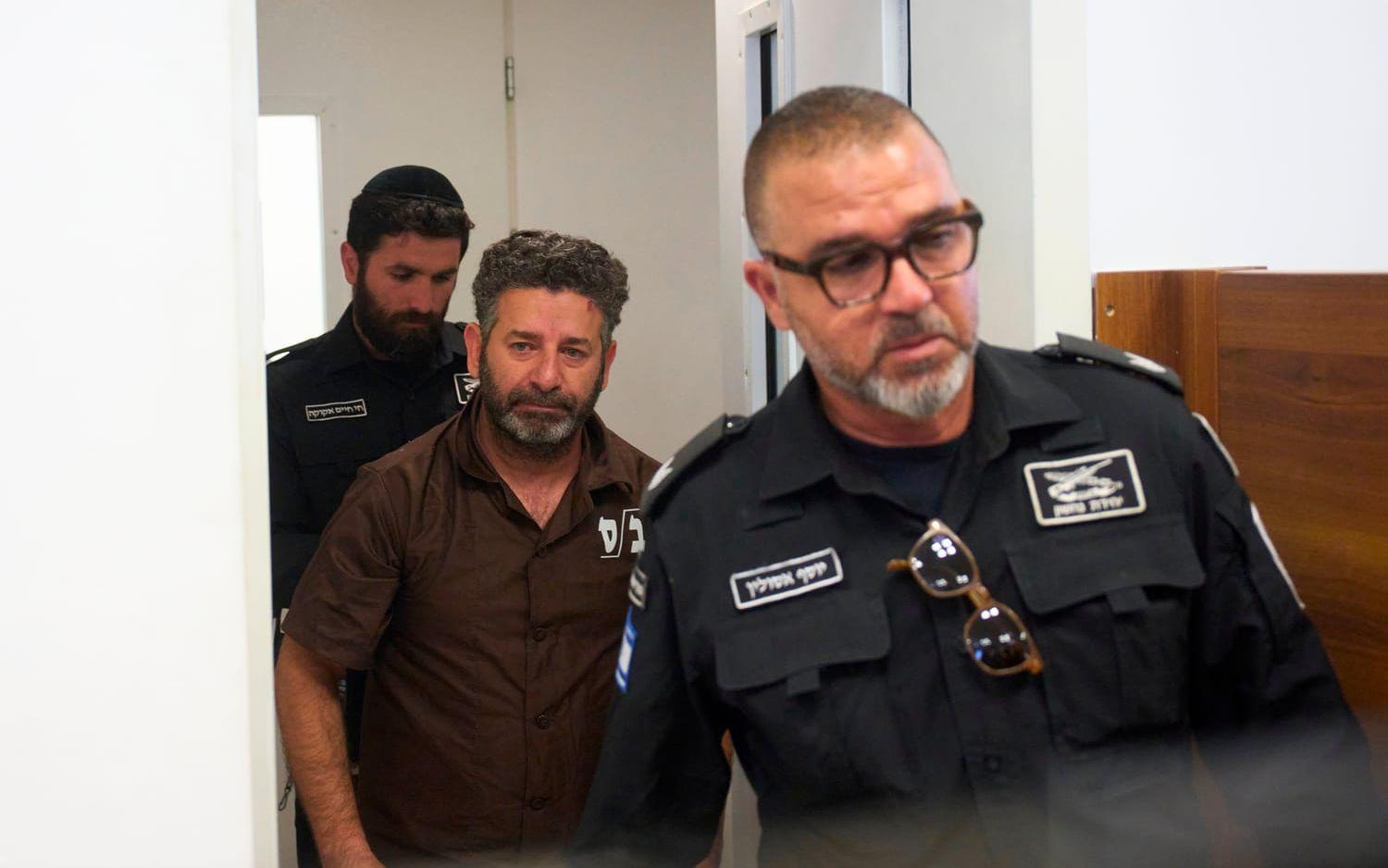 Svensk-spanske aktivisten Saif Abukeshek eskorteras av fängelsepersonal under söndagen.