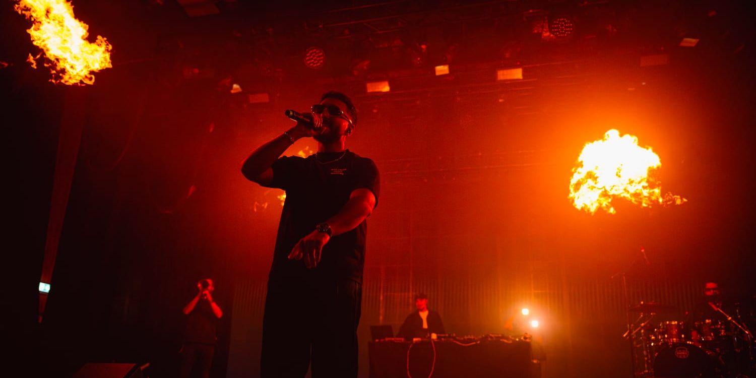 En svartklädd man med solglasögon på en scen