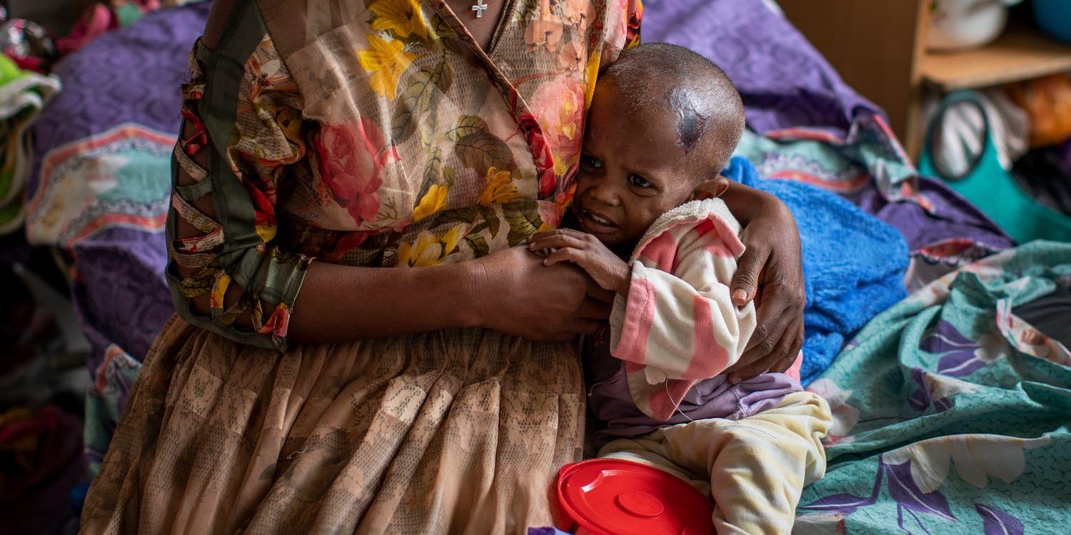 Den socialdemokratiska regeringen måste inse att situationen i världen – skenande matpriser, hungersnöd på Afrikas Horn, förtrycket i Myanmar, katastrofen i Afghanistan, klimatkrisen – gör det omöjligt att låta biståndet betala för det nödvändiga mottagandet av flyktingar från Ukraina, skriver debattörerna. På bilden: En mamma i Tigray, Etiopien, håller sin 22 månader gamla, undernärda son som bara väger drygt sex kilo.