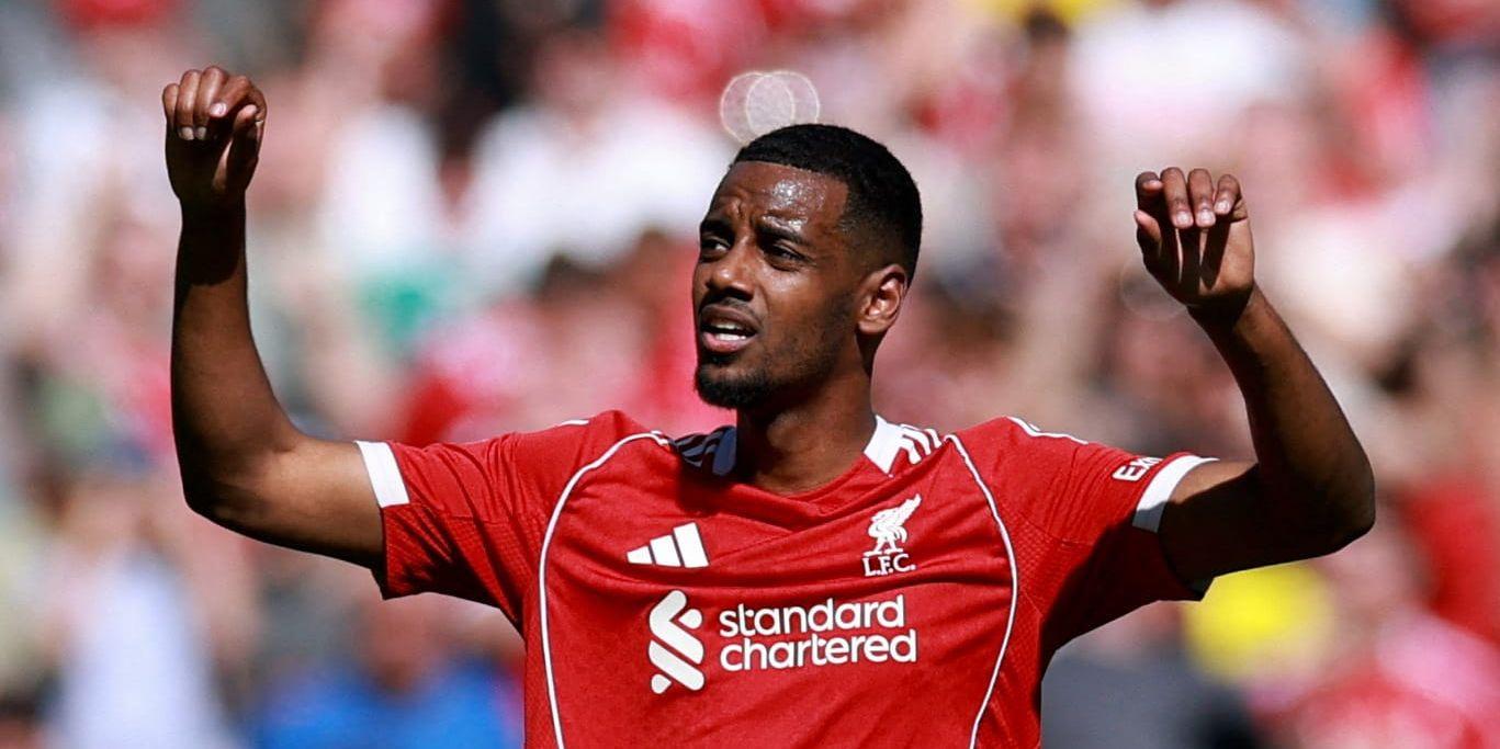 Alexander Isak i röd Liverpool-tröja lyfter händerna till skyn under den senaste matchen.