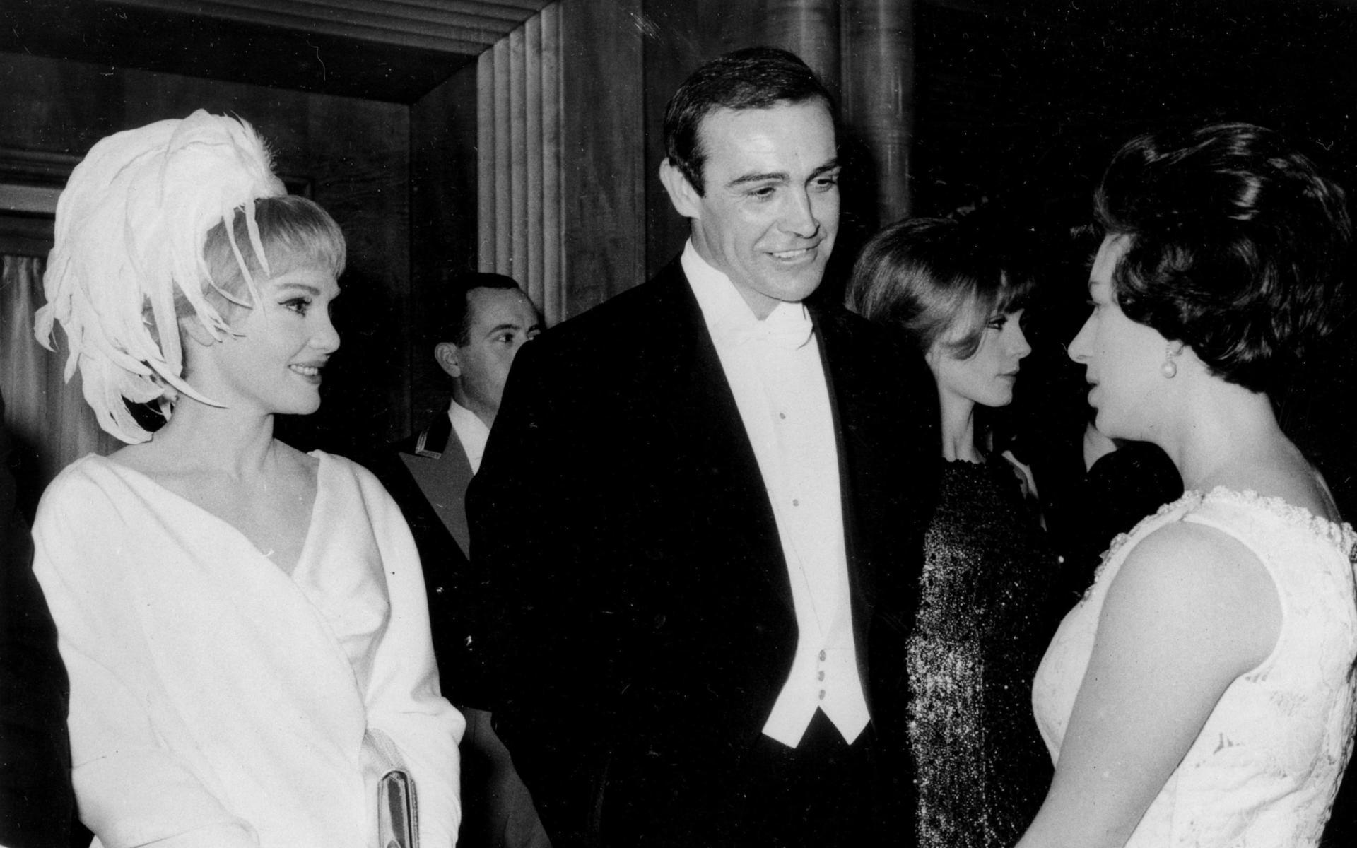 Sean Connery och hans första fru, skådespelerskan Diane Cilento i ett samtal med Prinsessan Margaret på Odeon Cinema i London 1965. Cilento hade en egen karriär som skådespelerska, men lät den avta efter att hon gift sig med Connery. De fick en son tillsammans, Jason Connery, som också han är skådespelare. Paret skilde sig 1973.