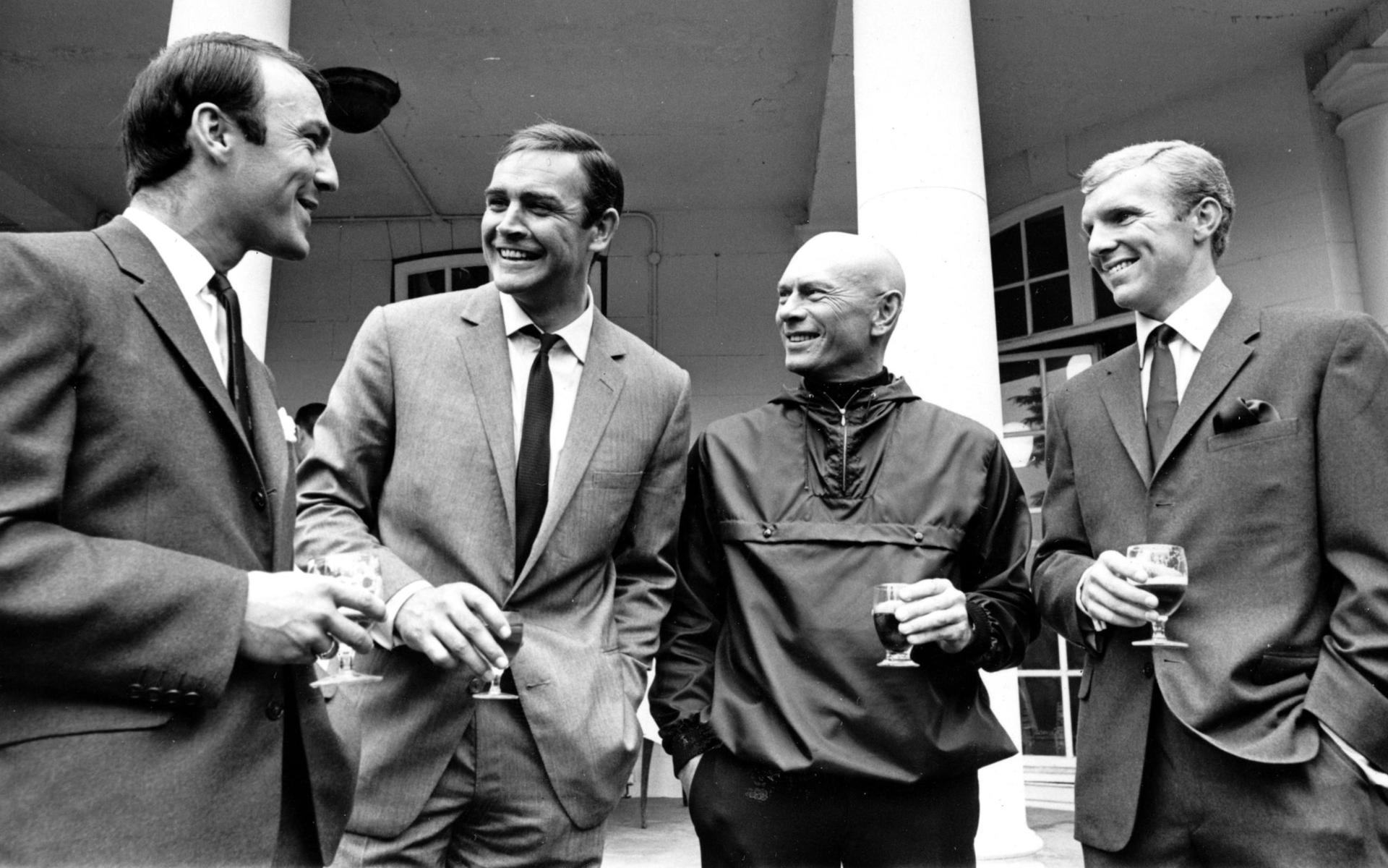 Jimmy Greaves till vänster och Bobby Moore till höger träffar Sean Connery och Yul Brynner, när det brittiska herrlandslaget i fotboll besökte Pinewood Studios i London -66.