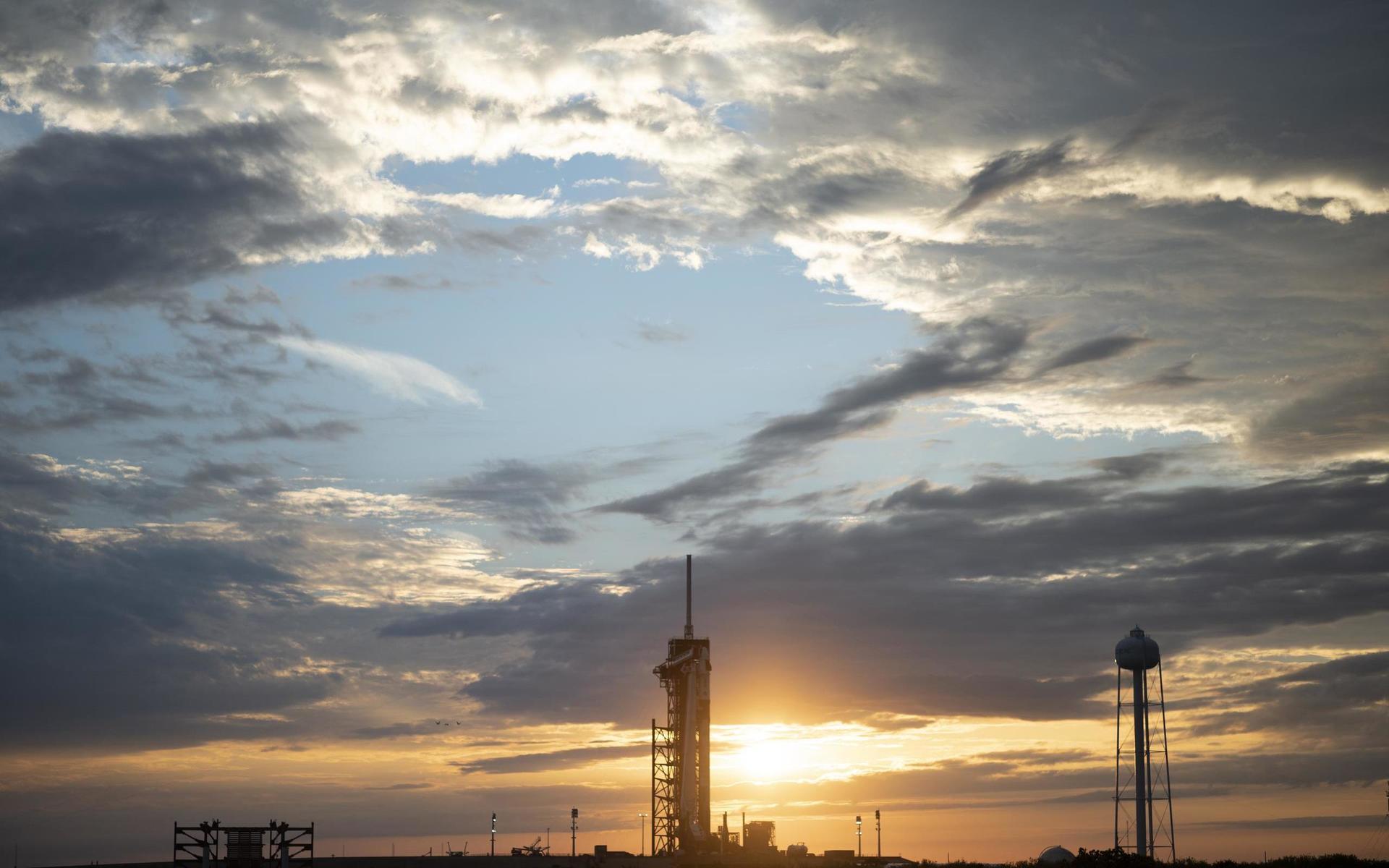 Bärraketen Falcon 9 och besättningskapseln Dragon i solendgång på startplatta 39A på Kennedy Space Center i Florida.