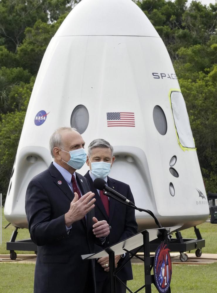 Nasas tjänstgörande chef Steve Jurczyk tillsammans med chefen för Kennedy Space Center Robert Cabana intill en modell av Dragon-kapseln. 