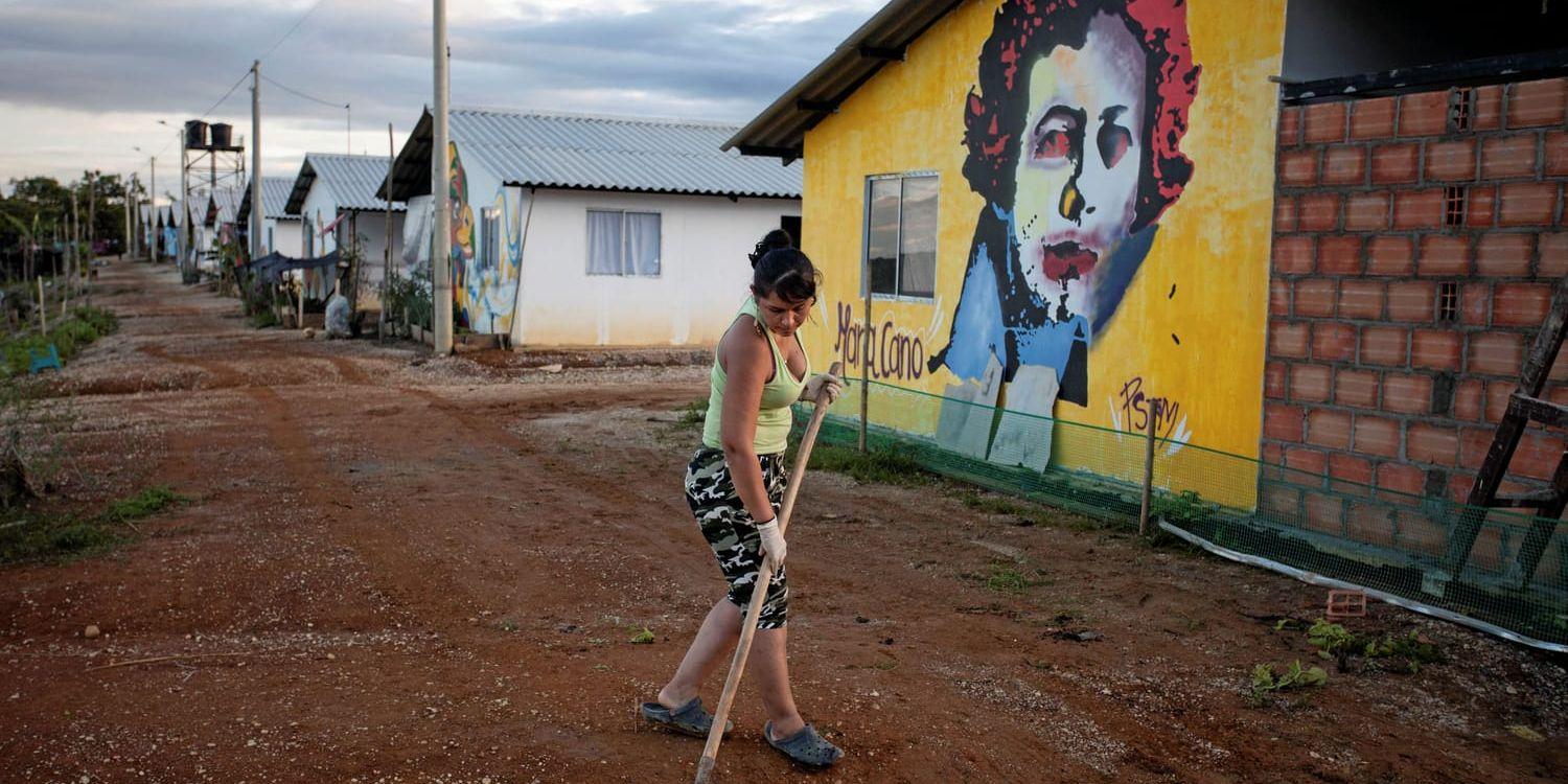 Före detta gerillasoldaten Lisbeth arbetar med att göra i ordning en av de egna vägarna i byn Agua Bonita.