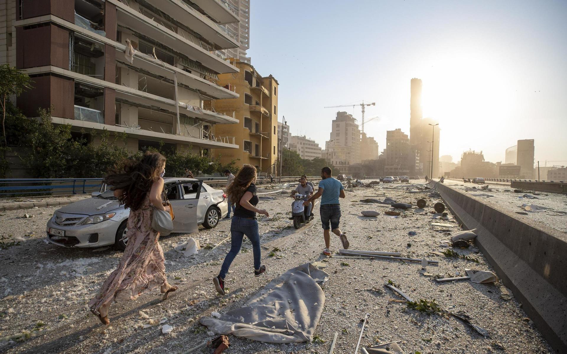 Invånare flyr i efterdyningarna av den kraftiga explosionen i Beiruts hamn. 