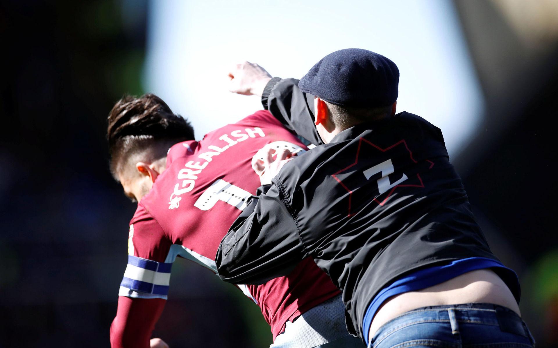 Skandalscener under mötet mellan Aston Villa och Birmingham när en supporter stormade planen och riktade ett knytnävsslag mot mittfältaren Jack Grealish