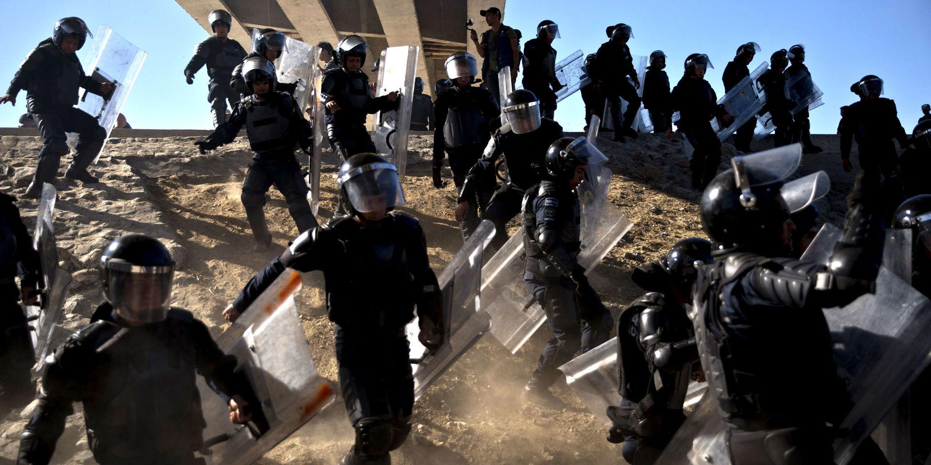 Mexikansk polis försöker stoppa migranter från att korsa gränsen.