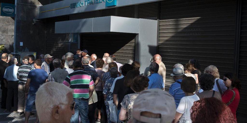 Äldre människor som brukar ta ut sin pension i kontanter är samlade utanför en stängd bank i Aten.