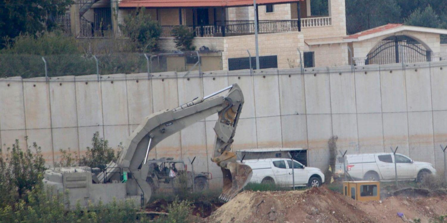 En grävskopa från den israeliska militären gräver vid staden Metula vid gränsen mellan Israel och Libanon.