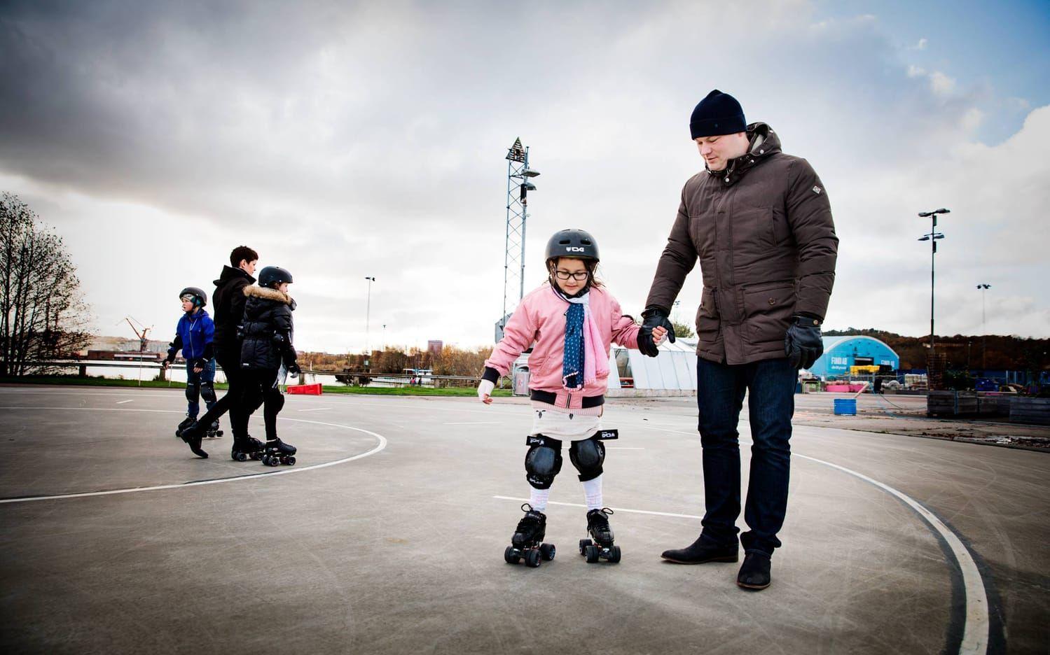 Nora Sewger, 7 år, får hjälp av sin bonuspappa Jonathan Kvist med att hålla balansen när hon testar på rullskridskor i Jubileumsparken.Foto: Jonas Lindstedt
