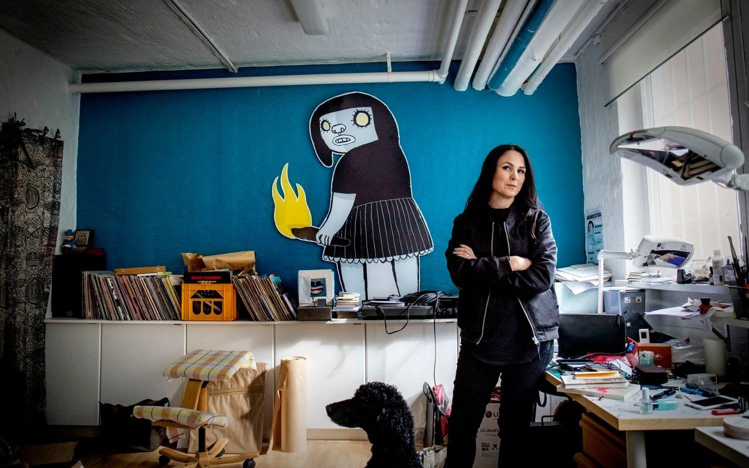 I ateljén. Nina Hemmingsson har sin huvudfigur på väggen i sin ateljé. Bild: Lisa Thanner
