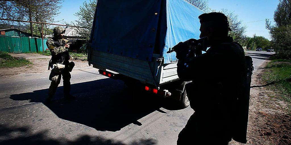 Proryska militanta separatister inspekterar en lastbil vid en vägspärr nära Slovjansk.