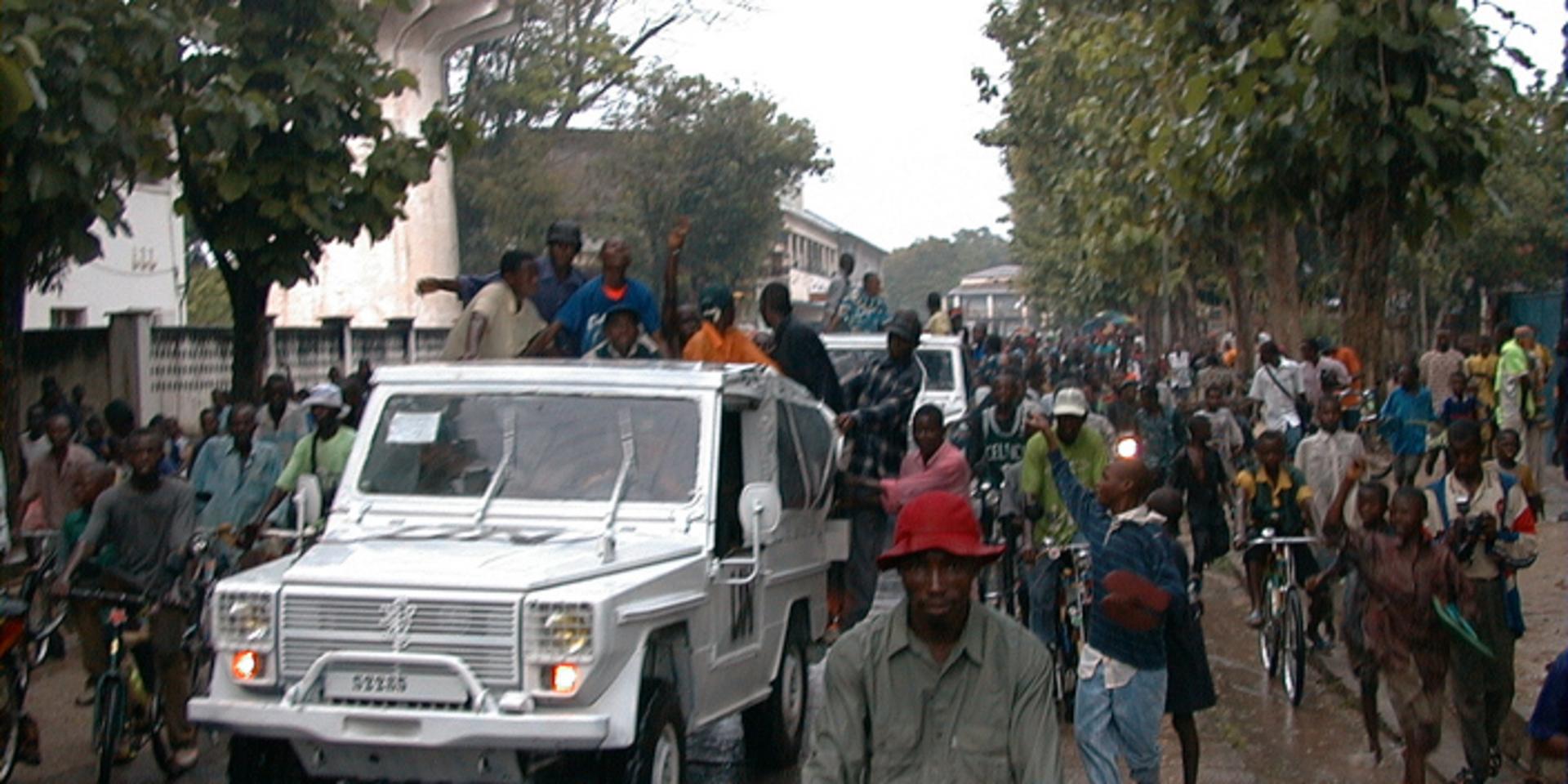 Demonstranter som ropar slagord mot Uganda och Rwanda tillsammans med en FN-bil i Kongo-Kinshasas tredje största stad Kisangani. Arkivbild från april 2001.