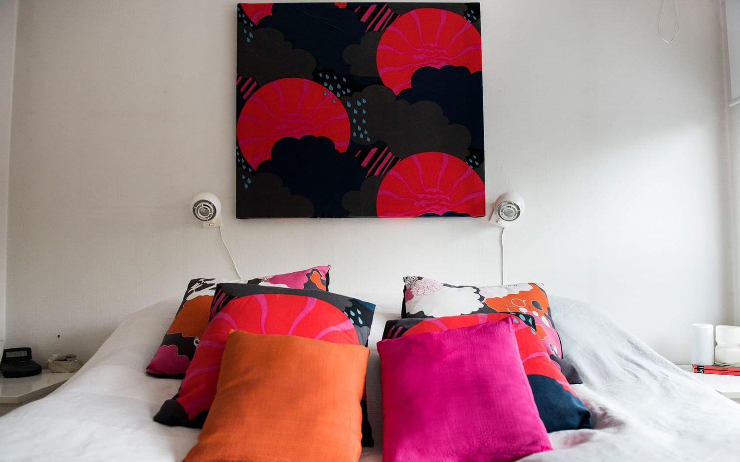 I Jonas och Heléns sovrum finns färgsprakande kuddar av både nyproducerat och loppisfyndat 1970-talstyg. Även tavlan på väggen är en textil. Foto: Pontus Lundahl/TT
