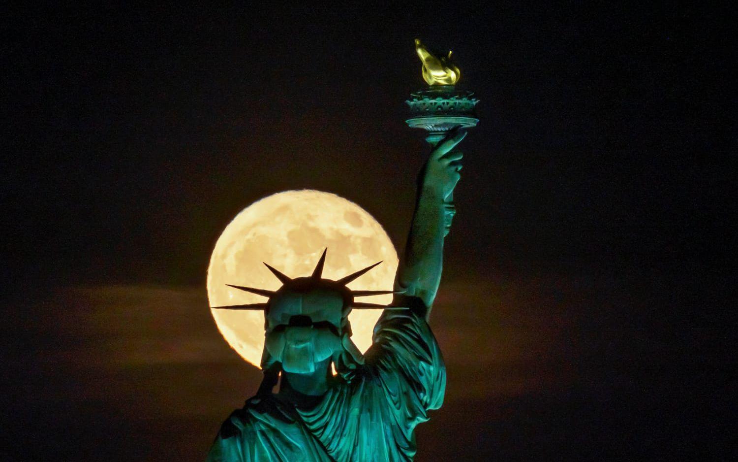 Frihetsgudinnan i förgrunden av en fullmåne. Arkivbild.