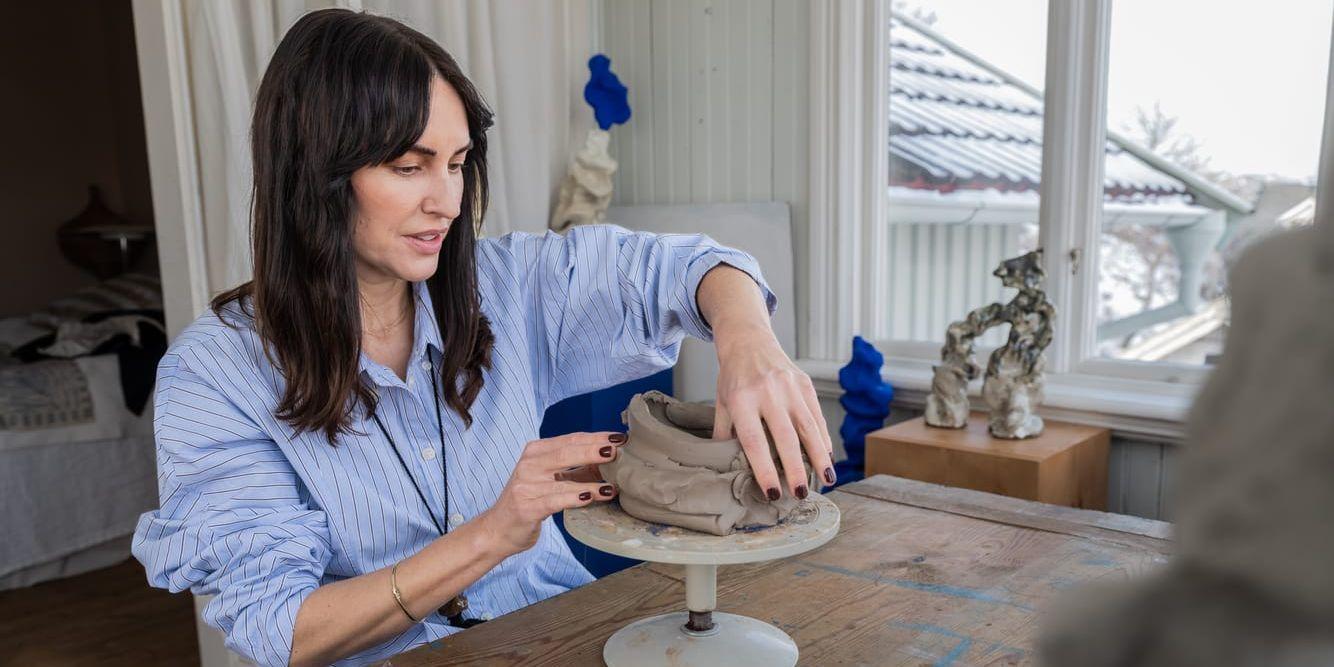 Malou Palmqvist formar en lerklump med händerna.