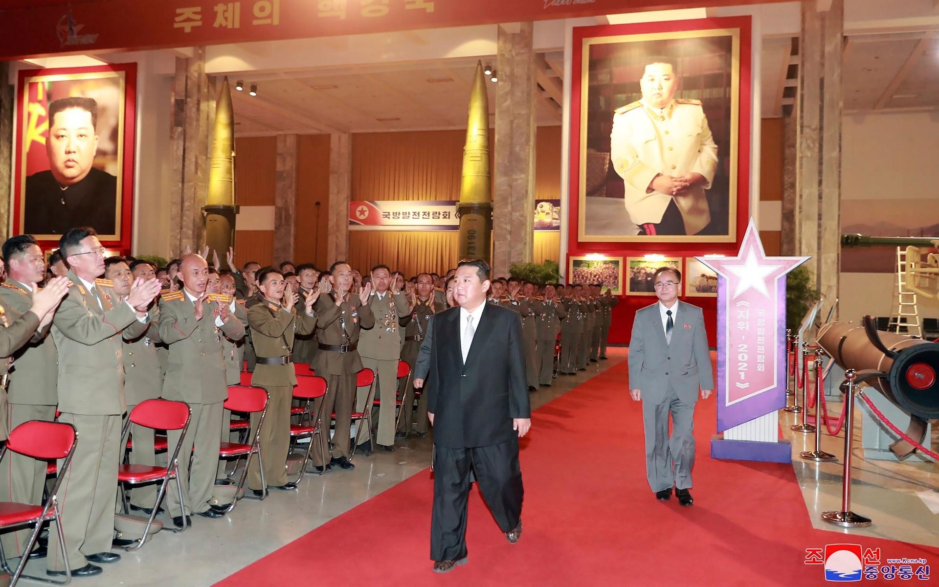 Kim Jong Un, ofta klädd i stora kostymer, går ner för den röda mattan.