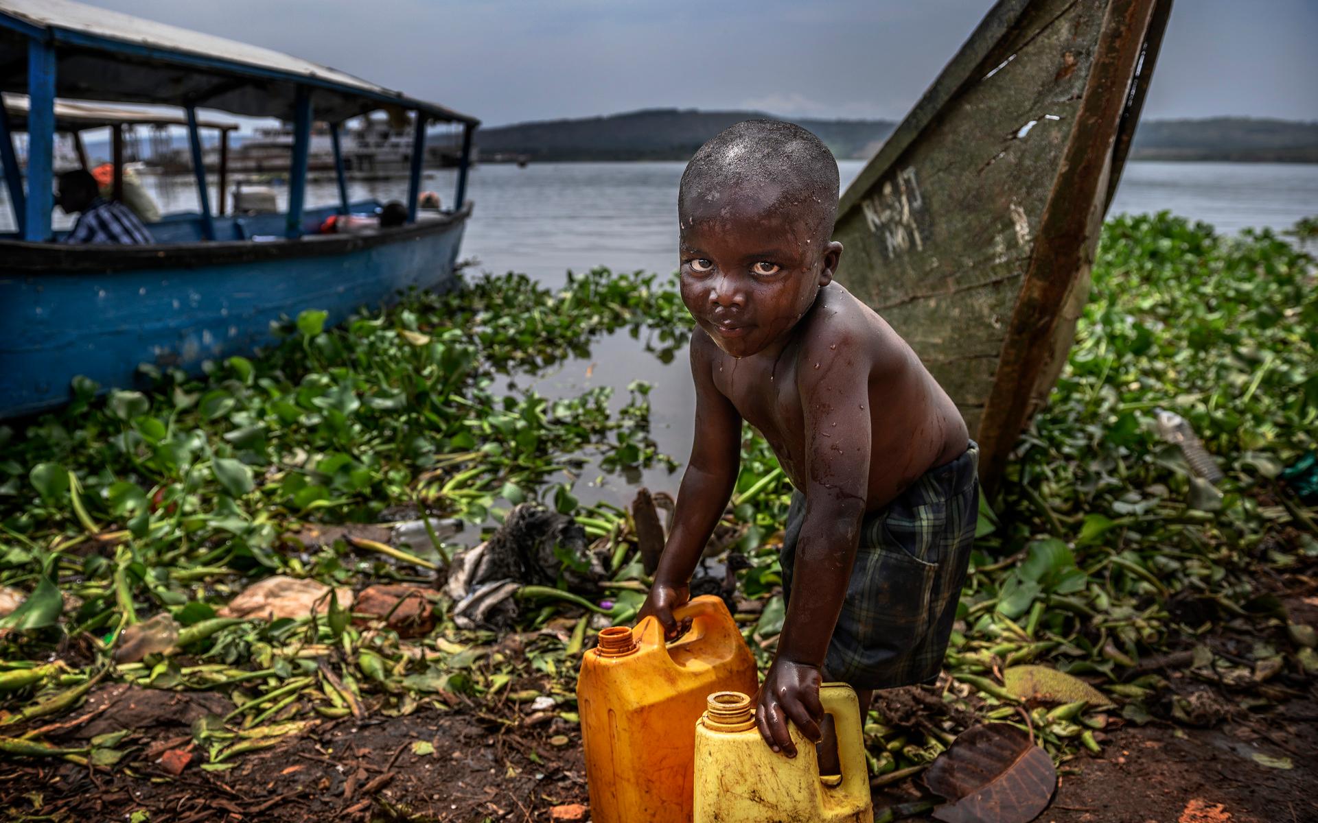 En pojke hämtar vatten från sjön i fiskeläget Ripon i utkanten av Jinja. I den här byn finns en enda kran, ditplacerad av myndigheterna, som ska förse alla tusentals invånarna med vatten. Det gör att många är hänvisade till Victoriasjöns förorenade vatten, även om de vet att det inte är bra för dem. 