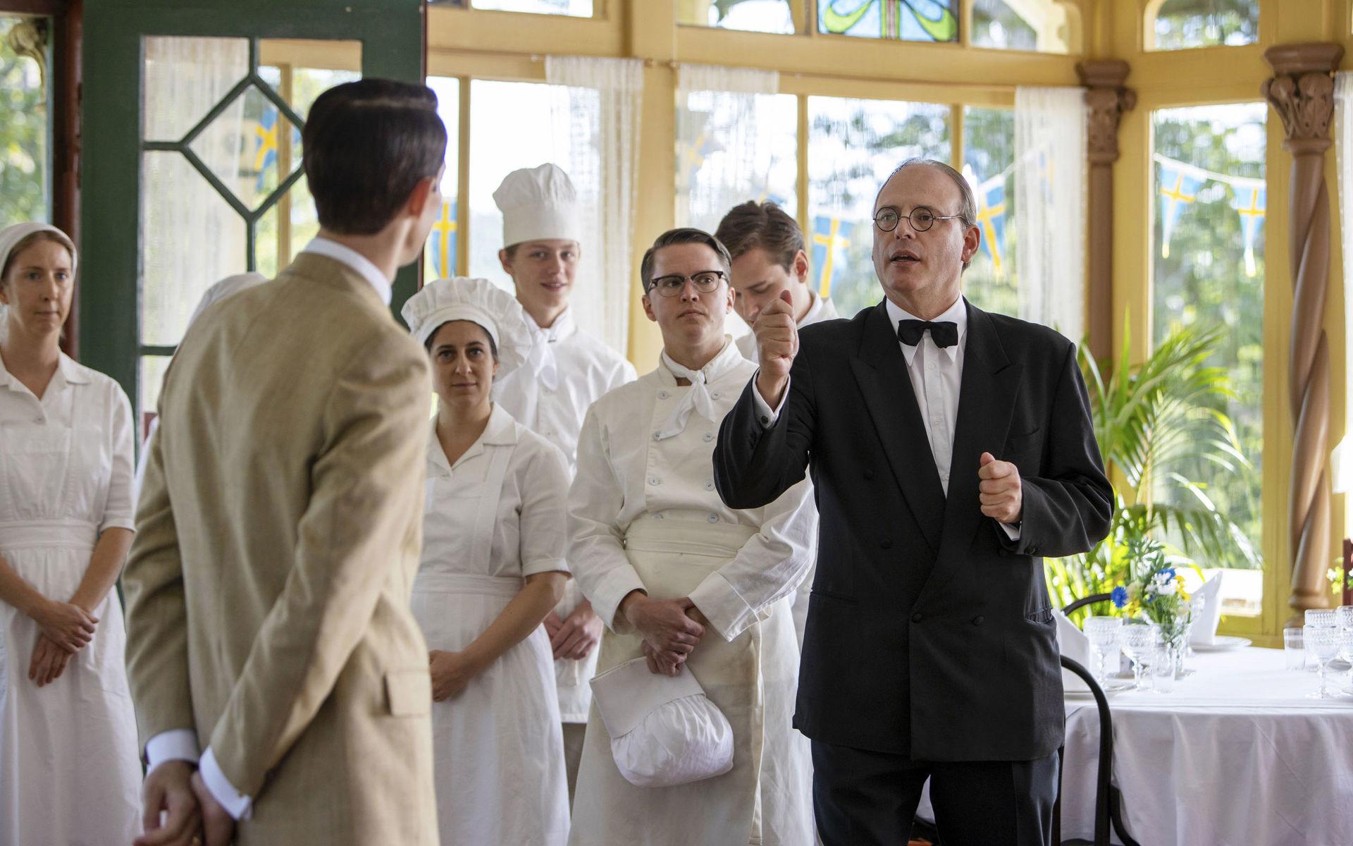 Hovmästaren Bellan (Rasmus Troedsson) hänger med till familjen Löwanders sommarrestaurang. Här delar han ut order till personalen. Restaurangens interiör är filmad i huset Vänhem, som ligger vid Nääs slott.