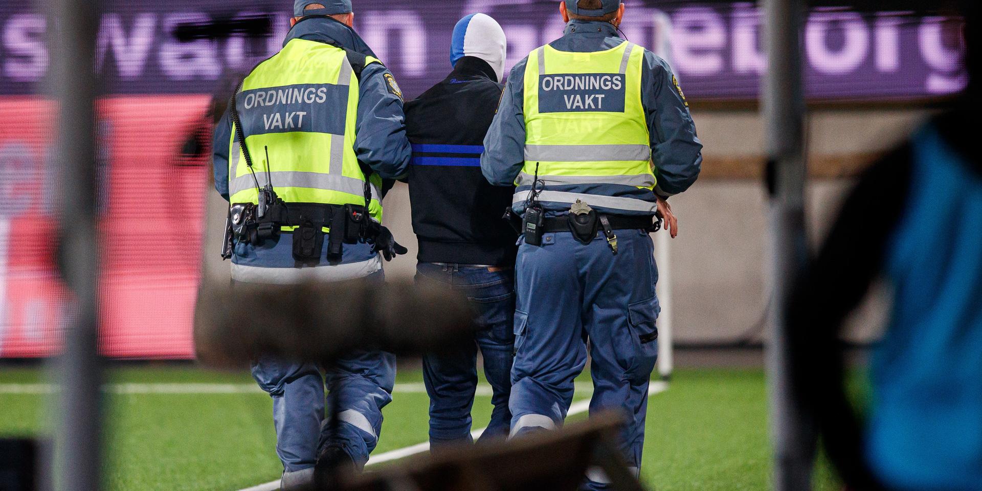Ordningsvakter för bort en planstormare under fotbollsmatchen i Allsvenskan mellan Häcken och IFK Norrköping. 