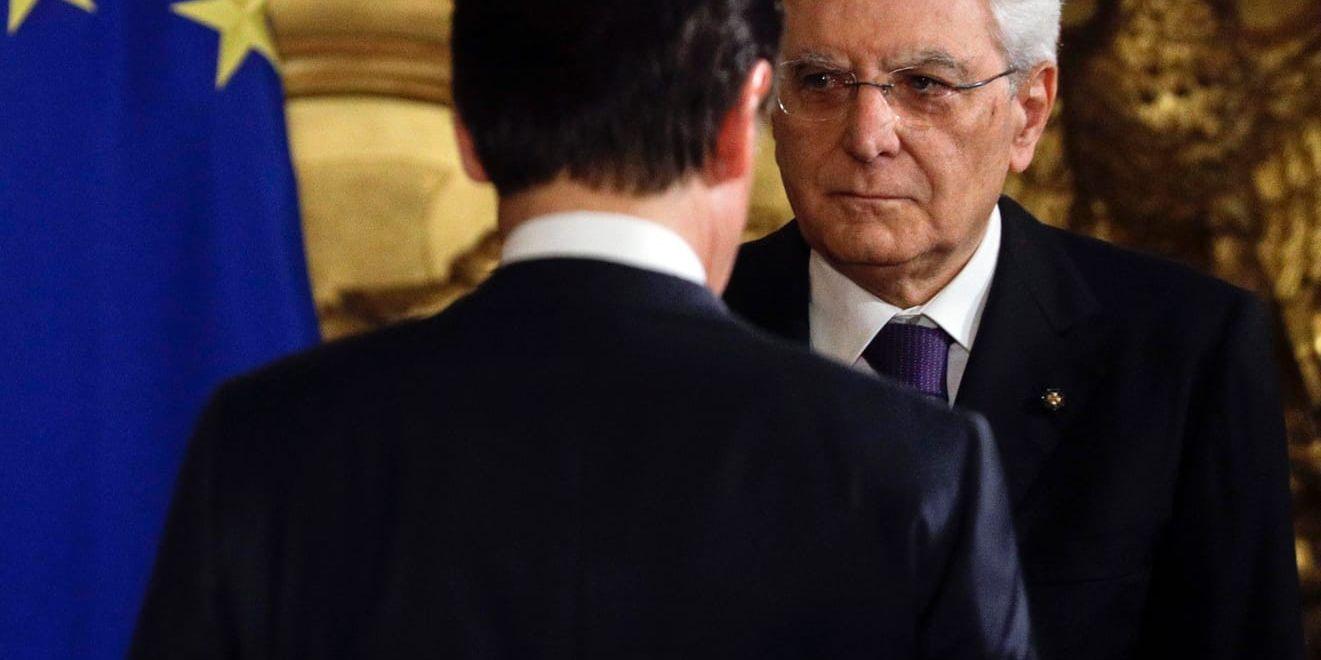 Italiens president Sergio Mattarella oroas av regeringens höga underskottsmål. Här står han vänd mot kameran med premiärminister Giuseppe Conte framför sig. Arkivbild från 1 juni.