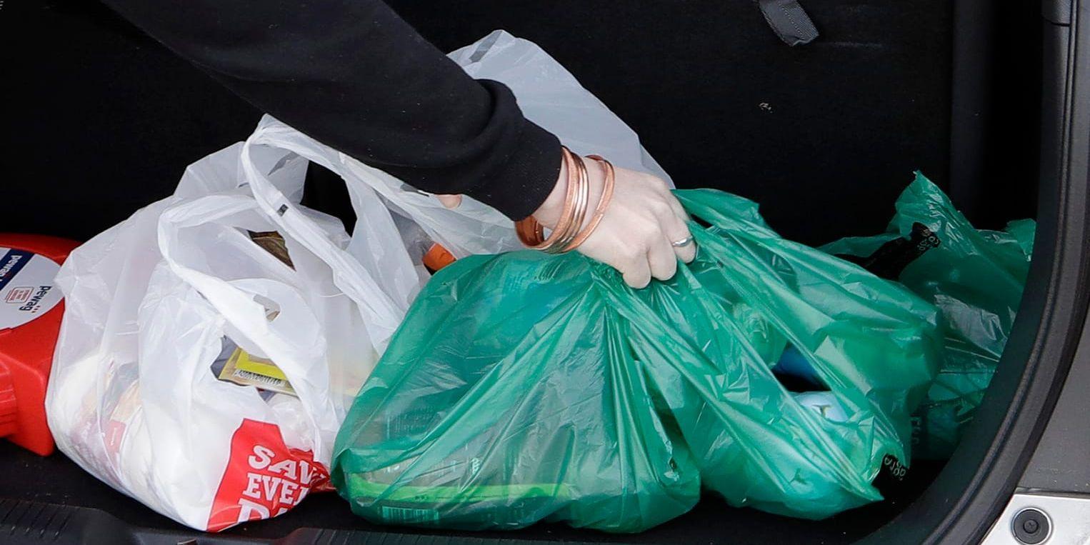 En kvinna tar med sig sin inhandlade mat i plastpåsar i Christchurch, Nya Zeeland.