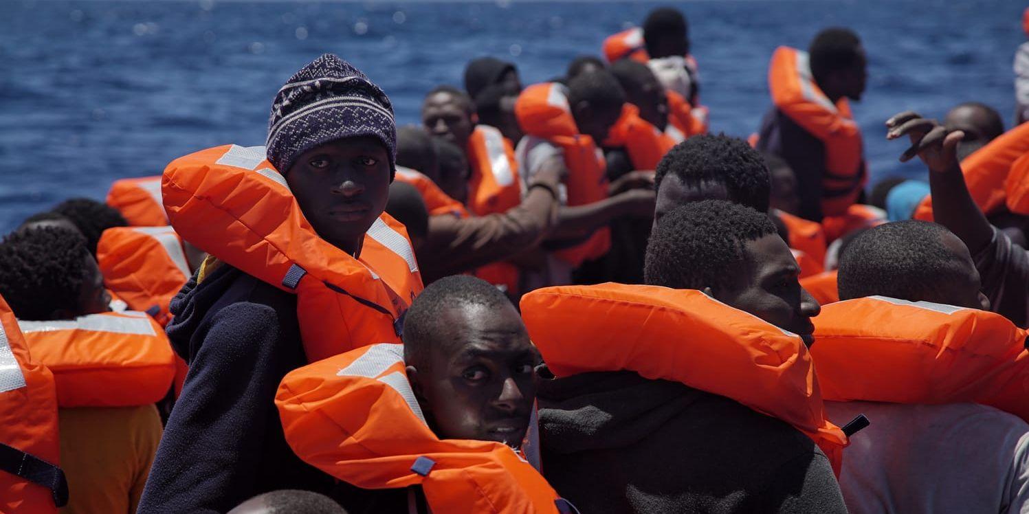 Migranter väntar i gummibåtar på att bli räddade av hjälporganisationer, vars personal förser dem med räddningsvästar innan de förs i säkerhet. Många av migranterna som försöker ta sig till Europa från Libyen är från länder söder om Sahara i Afrika.