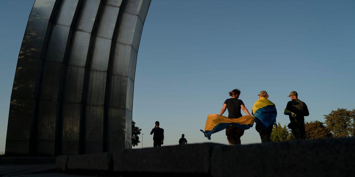 Attacken mot järnvägsstationen kom på onsdagen, då Ukraina högtidlighöll sin självständighetsdag. På bilden syns människor med ukrainska flaggor som i Kiev går förbi ett monument från sovjettiden.