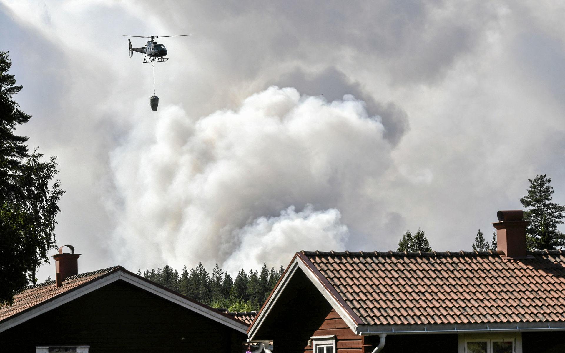 En helikopter hjälper till med släckningsarbetet vid en skogsbrand nära Färila, Ljusdal.